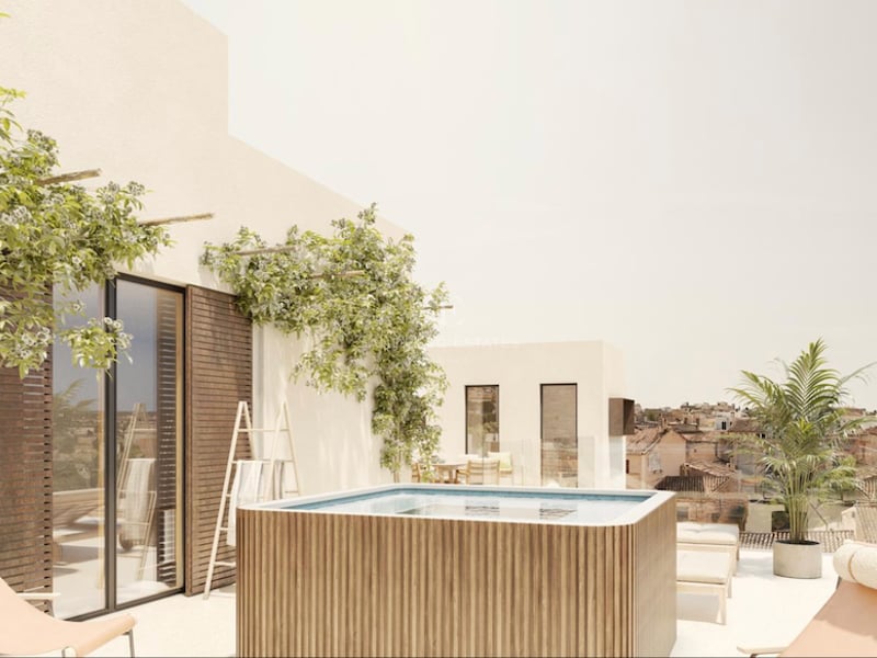 Terrasse sur le toit avec piscine en bois, chaises longues et plantes grimpantes surplombant une ville historique.