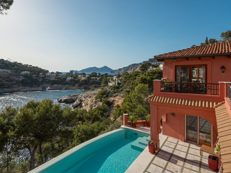 Vue d'une villa en terre cuite avec piscine à débordement donnant sur la mer Méditerranée et les montagnes.