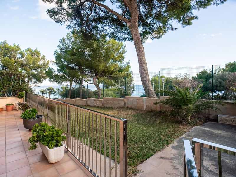 Terrasse en terre cuite surplombant un jardin privé avec des pins et une vue sur la mer Méditerranée.