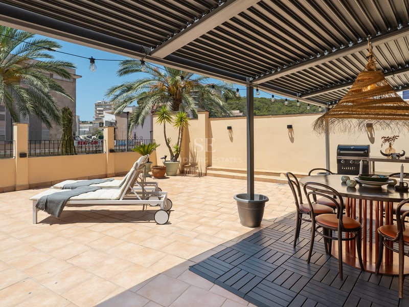 Terrasse ensoleillée avec pergola bioclimatique, salle à manger extérieure, barbecue et bains de soleil.