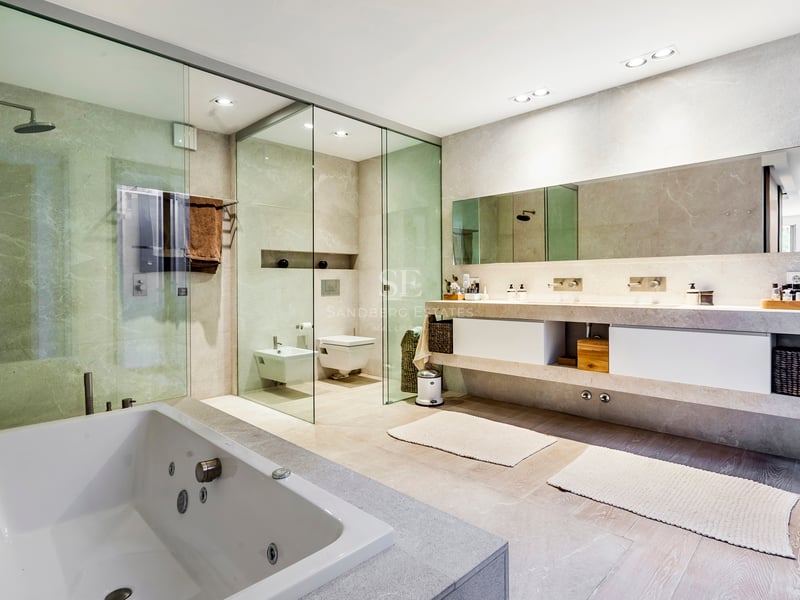 Salle de bains moderne avec douche à l'italienne, double vasque en pierre et baignoire balnéo.
