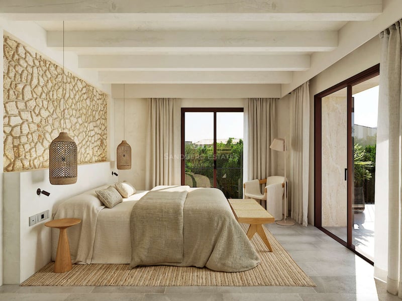 Chambre de luxe avec mur en pierre apparente, poutres en bois et baies vitrées donnant sur le jardin.