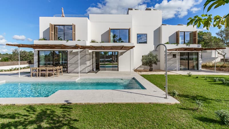 Moderne weiße zweistöckige Villa mit rechteckigem Pool, gepflegtem Rasen und Holzpergolen.