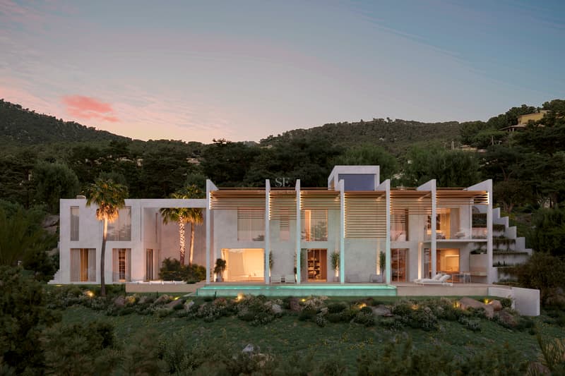 Façade d'une villa blanche moderne au crépuscule avec piscine à débordement et palmiers.