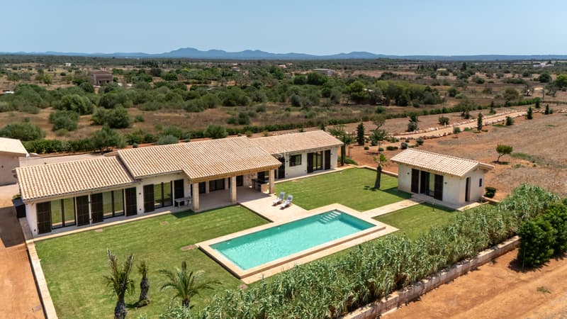 Moderne Finca mit Pool und Panoramablick Luftaufnahme einer modernen einstöckigen Villa mit türkisfarbenem Pool, Rasen und traditionellen Dachziegeln.