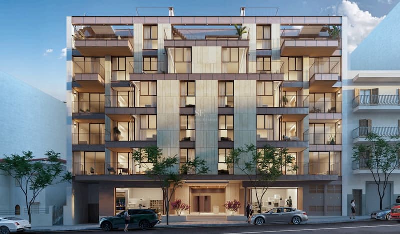 Frontvy av en modern sexvåningsbyggnad med beige stenbeklädnad, stora fönster och balkonger.