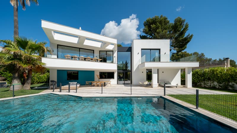 Villa contemporaine avec piscine privée Extérieur d'une villa blanche moderne avec grande piscine, balustrades en verre et palmiers.