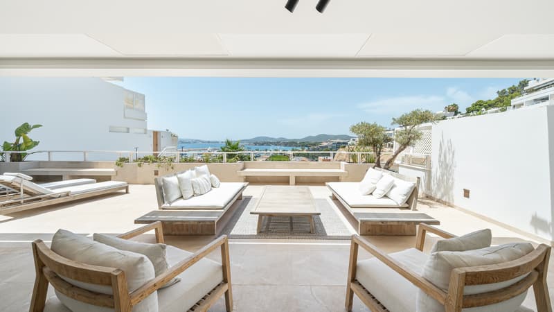 Terrasse de luxe avec vue panoramique sur la mer Grande terrasse blanche avec canapés et fauteuils en bois surplombant la mer bleue et la côte par une journée ensoleillée.
