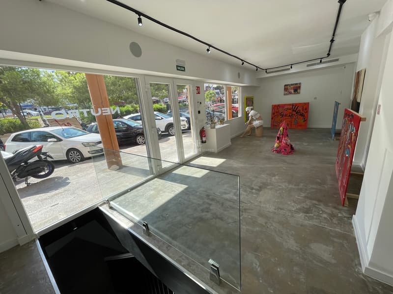 Galerie d'Art et Espace Créatif Moderne Intérieur de style industriel avec sols en béton poli, éclairage sur rail et grandes baies vitrées.