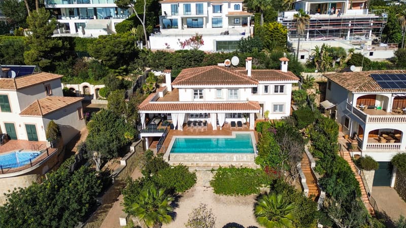 Villa Méditerranéenne avec Piscine Privée et Terrasses Vue aérienne d'une villa blanche à toit de tuiles avec piscine turquoise et jardins luxuriants.