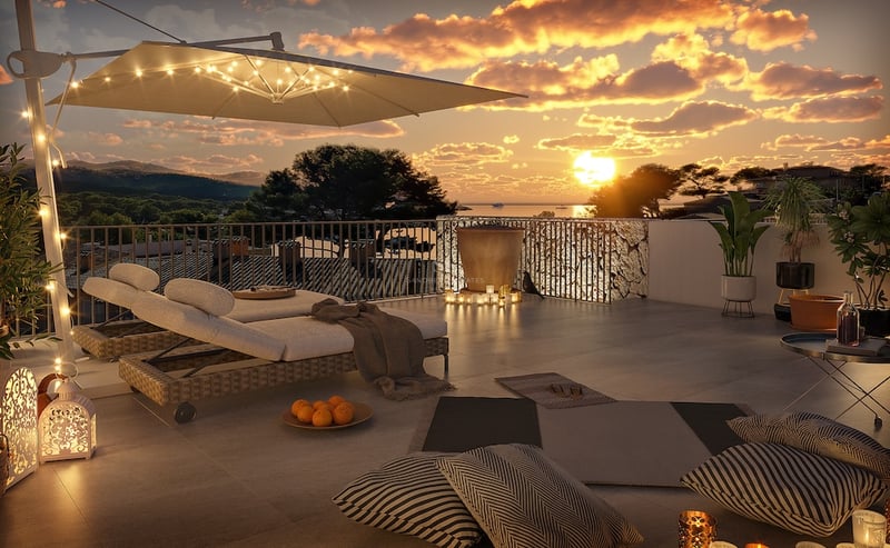 Terrasse de luxe au coucher du soleil avec chaises longues design, éclairage chaleureux et vue panoramique sur la mer.