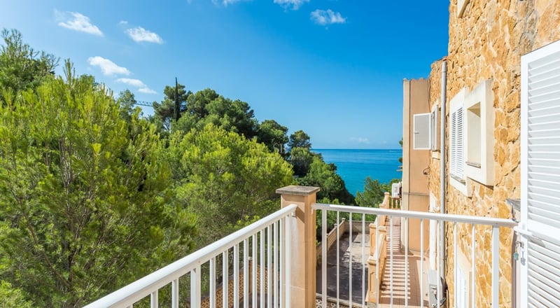 Vue extérieure d'une villa moderne avec piscine, jardin luxuriant et grandes fenêtres. Architecture minimaliste, éclairage ambiant.