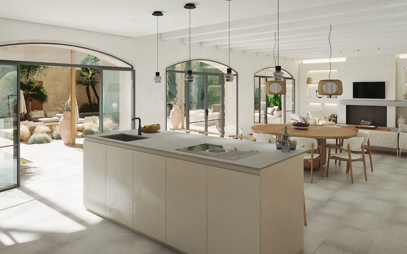 Isla de cocina moderna frente a comedor y patio mediterráneo con puertas de arco y techos de vigas blancas.