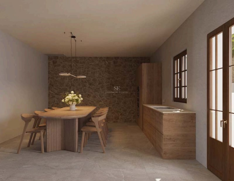 Salle à manger moderne avec table ovale en chêne, huit chaises, mur en pierre naturelle et lumière latérale.