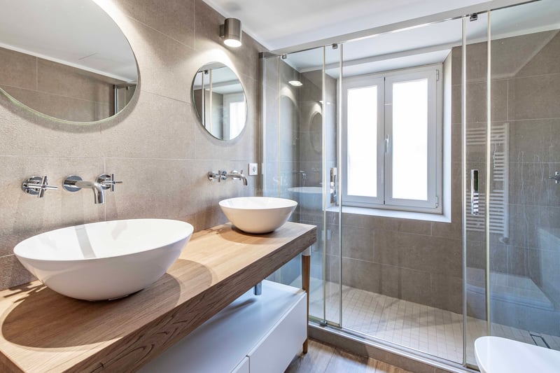 Salle de bains contemporaine avec double vasque en céramique, plan en bois et douche à l'italienne vitrée.