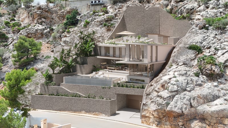 Villa moderne sur plusieurs niveaux intégrée dans une falaise avec piscine à débordement et baies vitrées.