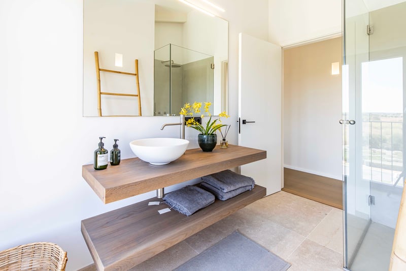 Minimalist bathroom featuring a floating double-tier oak vanity, white vessel sink, and large wall-mounted mirror.
