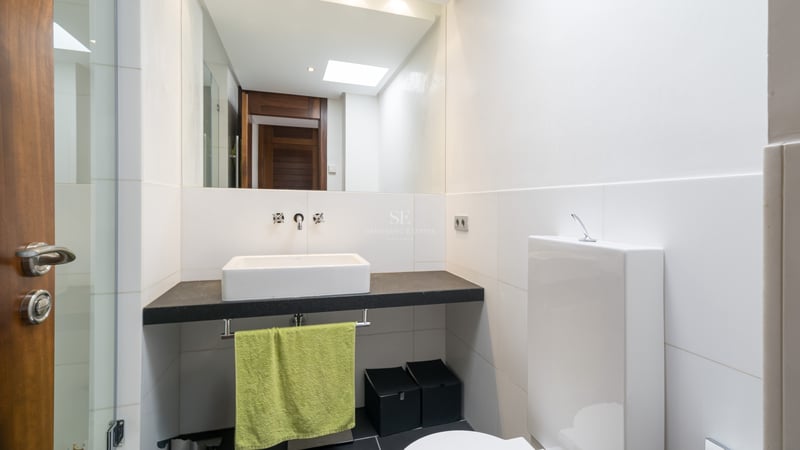 Salle de bains contemporaine avec vasque à poser sur plan en pierre sombre et grand miroir.