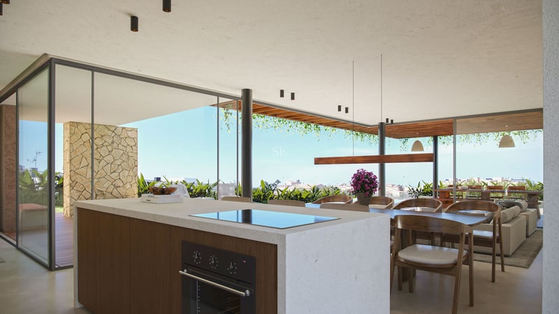 Îlot de cuisine luxueux en pierre, salle à manger en bois et baies vitrées ouvrant sur une terrasse.