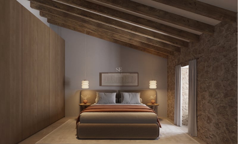 Chambre avec plafond en poutres de bois, mur en pierre naturelle et placards intégrés en chêne.
