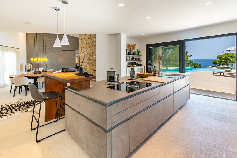 Vue extérieure d'une villa moderne avec piscine à débordement, végétation luxuriante et design architectural contemporain. Éclairage doux et ambiance luxueuse.
