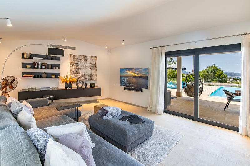 Vue extérieure d'une villa moderne avec piscine à débordement, jardin luxuriant et vastes terrasses. Design minimaliste et finitions haut de gamme.