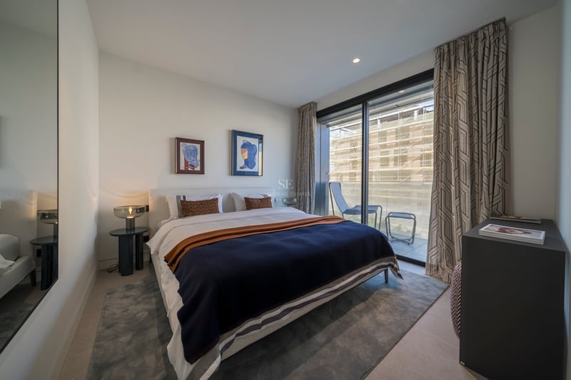 Chambre à coucher contemporaine avec un grand lit, des baies vitrées et une terrasse privée attenante.