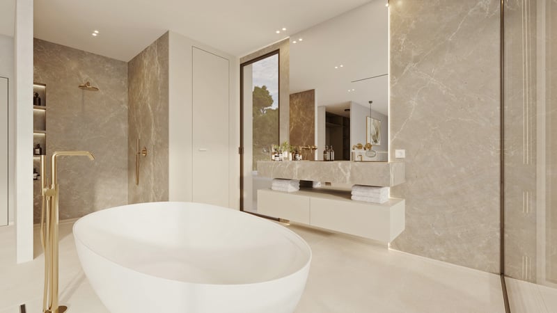 Salle de bain moderne avec baignoire îlot blanche, murs en marbre beige et robinetterie dorée.