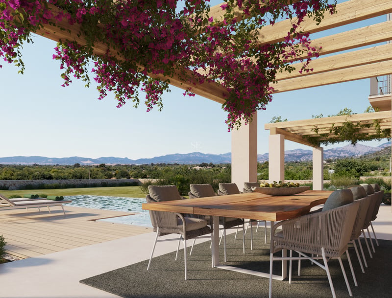 Table à manger en bois sous une pergola de bougainvilliers surplombant une piscine et des montagnes.