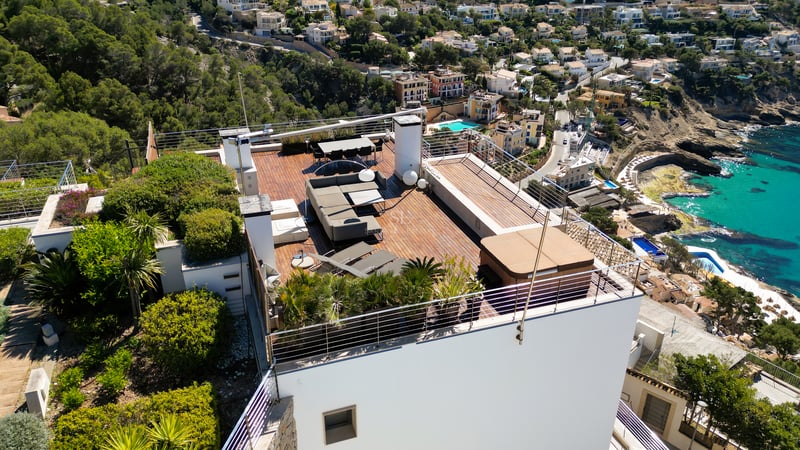 Vue aérienne d'une terrasse moderne en bois sur un toit, équipée d'un jacuzzi, d'un salon de jardin et d'un coin repas.