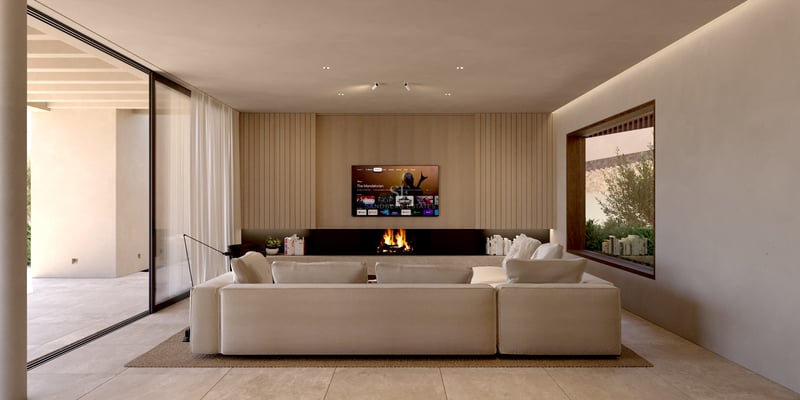 Vaste salon avec canapé d'angle beige, cheminée linéaire et mur TV orné de panneaux de bois clair.