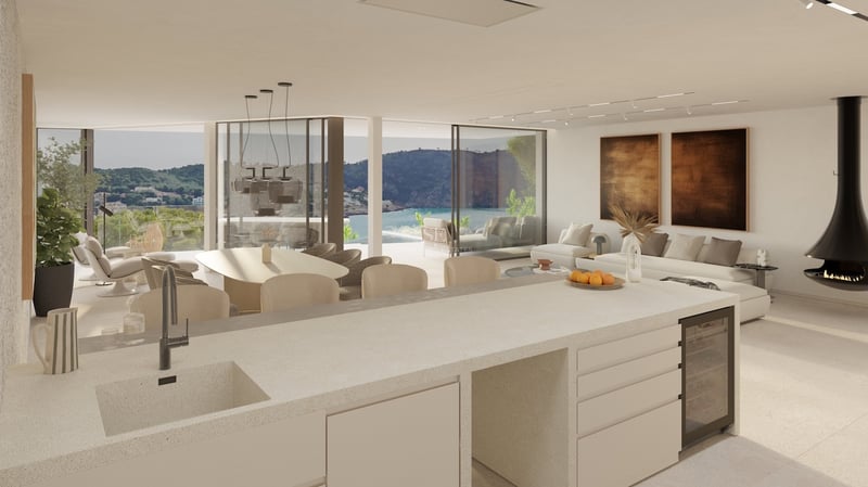 Grand salon ouvert avec cuisine, cheminée suspendue et baies vitrées offrant une vue imprenable sur la côte.