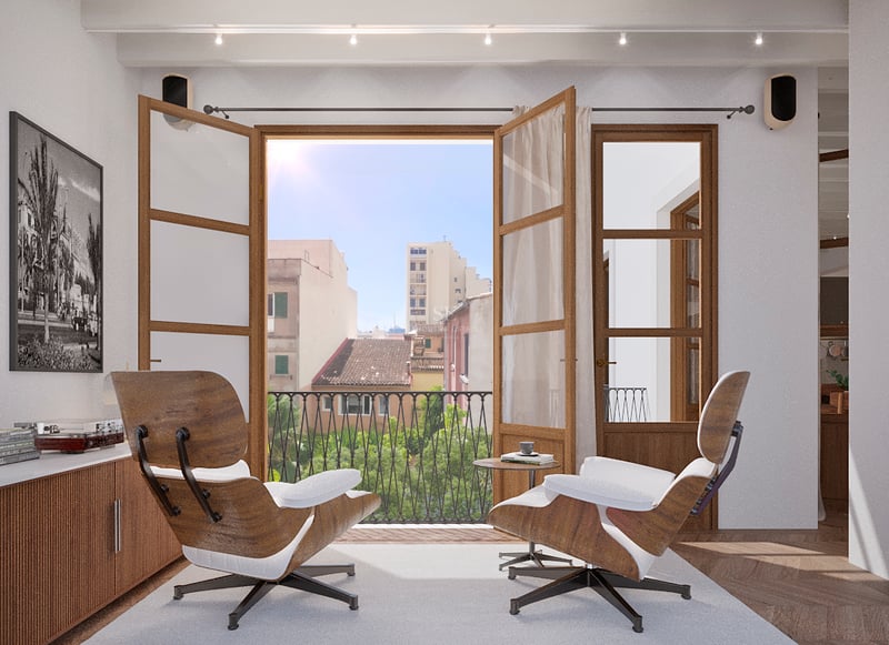 Salon lumineux avec deux fauteuils Eames face à un balcon ouvert offrant une vue sur une ville méditerranéenne.