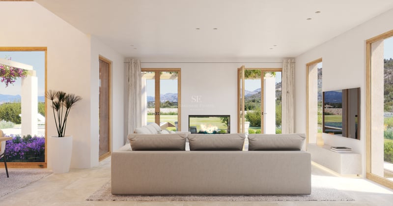 Salon moderne lumineux avec grandes portes en chêne, canapé beige, sol en pierre et cheminée face au jardin.