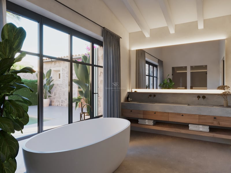 Une salle de bain principale minimaliste avec baignoire îlot, meuble en bois et béton, et grandes fenêtres sur cour.