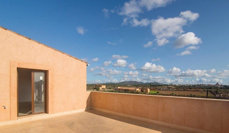 Grande terrasse en rooftop avec sol en pierre naturelle et vue imprenable sur la campagne et les montagnes.