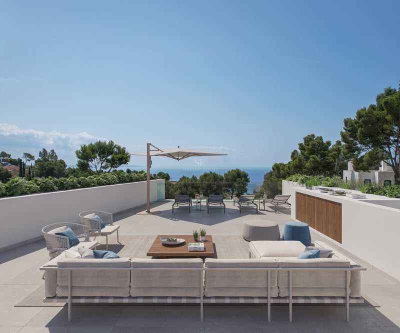 Grande terrasse moderne avec canapés, chaises longues et vue imprenable sur la mer Méditerranée.