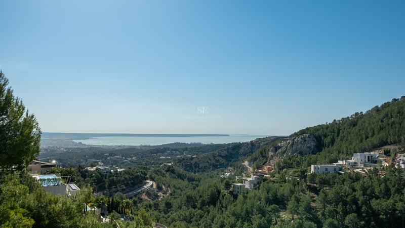 Villas blanches modernes nichées dans une pinède surplombant la mer Méditerranée et l'horizon.