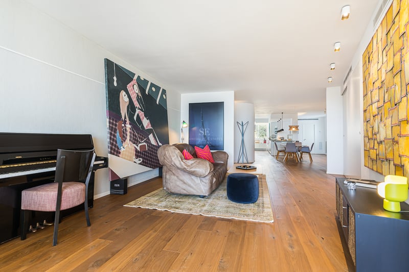 Vue d'une villa moderne avec piscine à débordement, chaises longues et végétation luxuriante. Design élégant et contemporain.