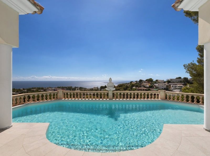Piscine surélevée avec balustrade en pierre surplombant la mer Méditerranée et la côte environnante.