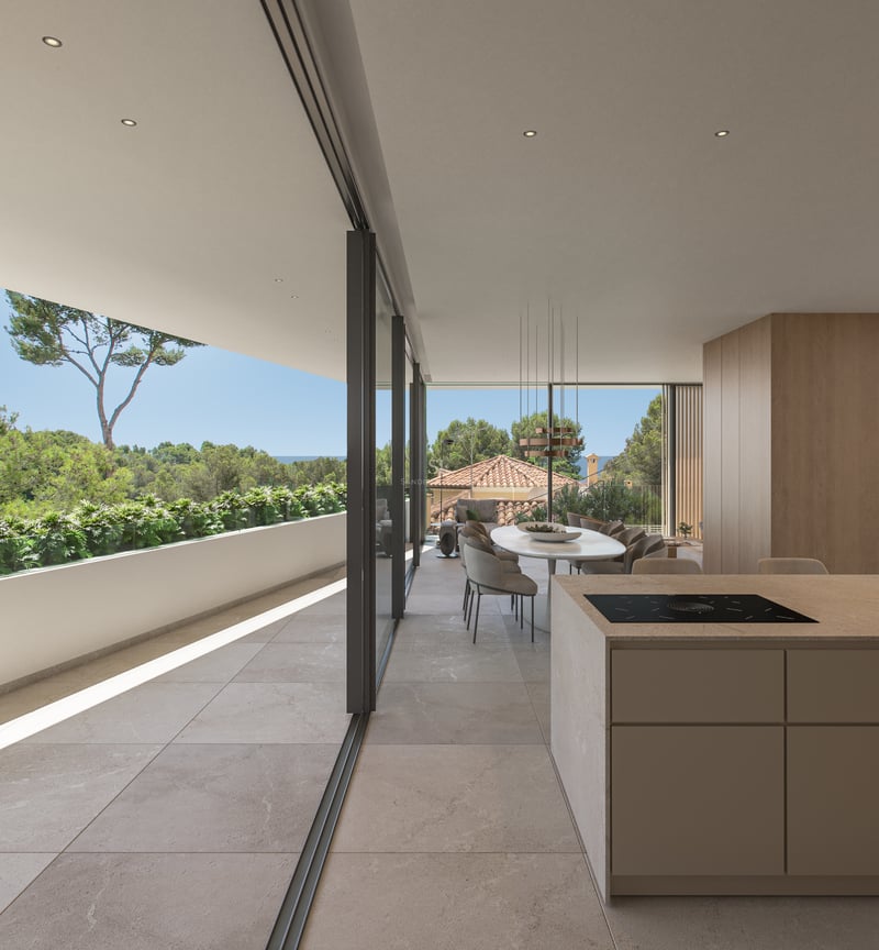 Salle à manger moderne à aire ouverte avec îlot de cuisine et grandes baies vitrées ouvrant sur une terrasse et la mer.