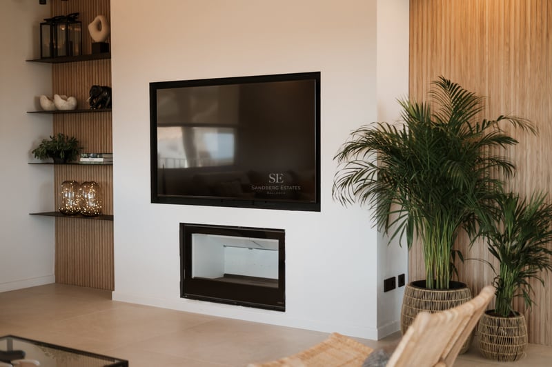 Mur blanc moderne avec un grand téléviseur au-dessus d'une cheminée minimaliste et des panneaux en chêne.