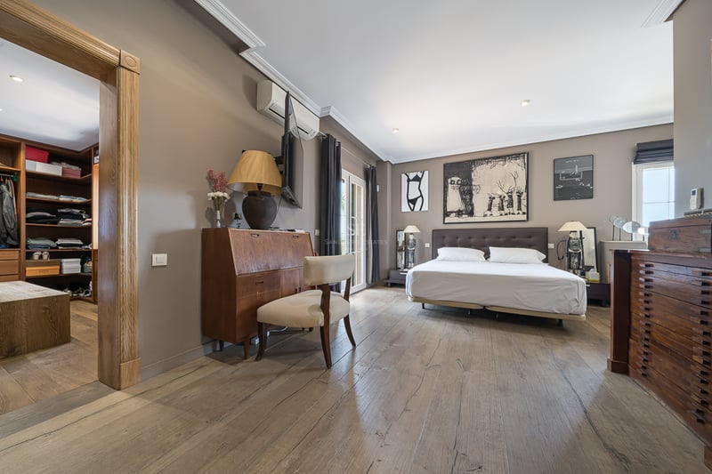 Grande chambre principale avec parquet en chêne à larges lames, lit double et dressing attenant.
