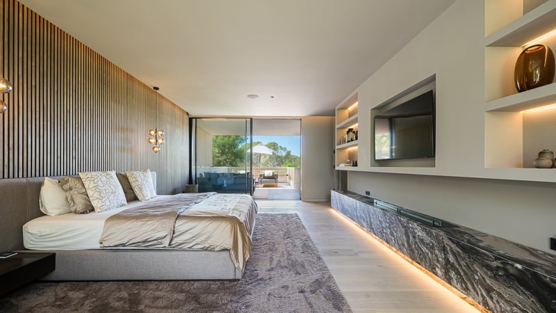 Chambre moderne avec mur en tasseaux de bois, grand lit, accents de marbre et accès à la terrasse.