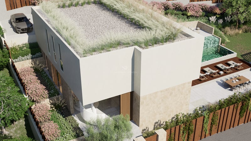 Vue aérienne d'une villa contemporaine avec toit végétalisé, piscine à débordement et espaces extérieurs paysagers.