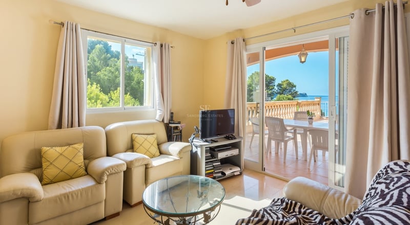 Intérieur lumineux avec grandes fenêtres, parquet clair, mobilier moderne. Vues panoramiques sur la mer.