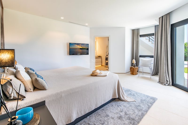Grand balcon avec vue sur la mer, mobilier moderne, balustrade en verre, plancher en bois, idéal pour profiter du plein air.
