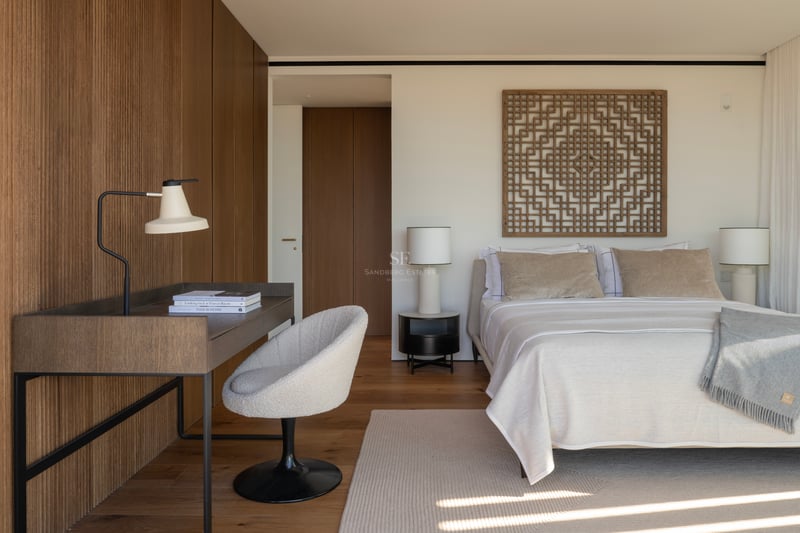 Chambre moderne avec mur en tasseaux de bois, bureau intégré, chaise en bouclé et textiles aux tons neutres.