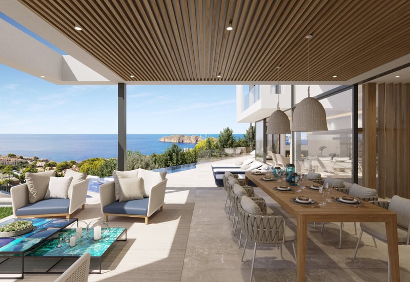 Terrasse couverte avec grande table à manger en bois, salon de jardin et piscine à débordement face à la mer.